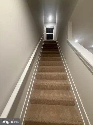 a view of kitchen with stainless steel appliances granite countertop a stove a sink a refrigerator and white cabinets with wooden floor