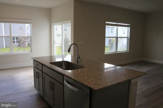 a kitchen with stainless steel appliances granite countertop a sink stove and wooden floor