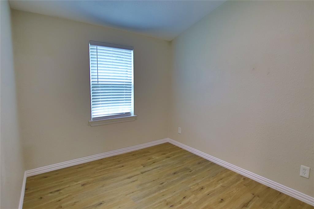 142 Andrea Street, Unit B Pottsboro, TX 75076 - Photo 15 of 22 an empty room with wooden floor and a window