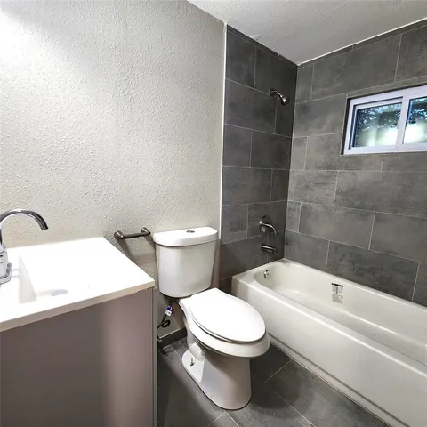 a white toilet sitting next to a bathroom sink and tub
