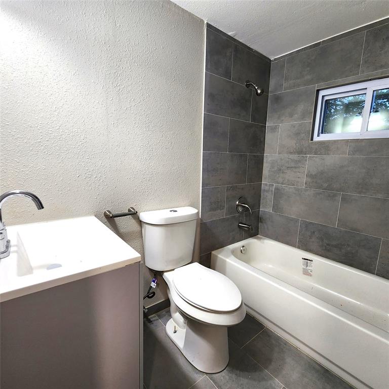 142 Andrea Street, Unit B Pottsboro, TX 75076 - Photo 17 of 22 a white toilet sitting next to a bathroom sink and tub