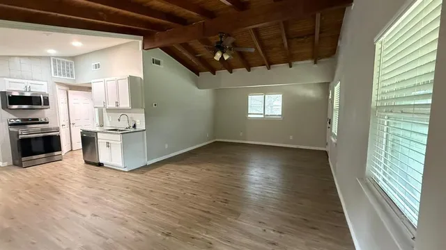 a view of a kitchen with a sink oven window and wooden floor