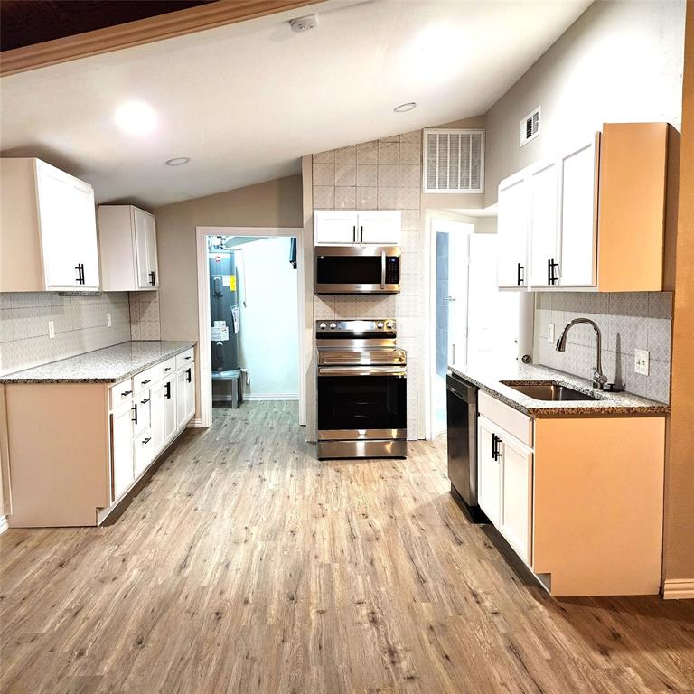 142 Andrea Street, Unit B Pottsboro, TX 75076 - Photo 7 of 22 a kitchen with stainless steel appliances a stove top oven a sink and a refrigerator