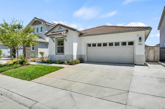 a front view of a house with a garden and garage