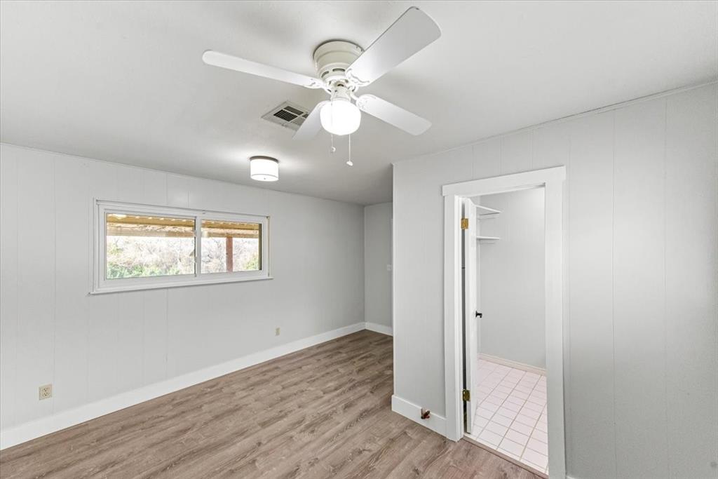 334 County Road 1296 Morgan, TX 76671 - Photo 14 of 32 an empty room with wooden floor fan and windows
