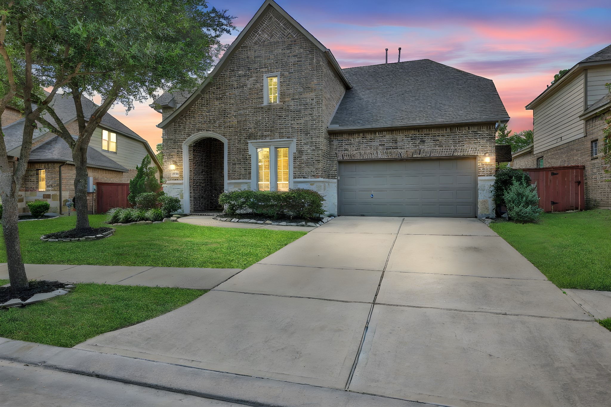 a front view of a house with yard and green space