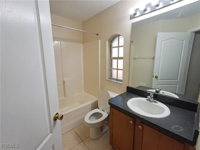 a bathroom with a granite countertop sink toilet a mirror and shower