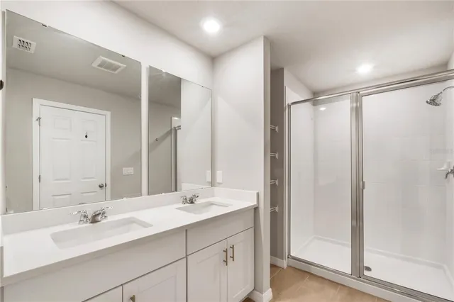 a bathroom with a bathtub shower sink vanity mirror and toilet