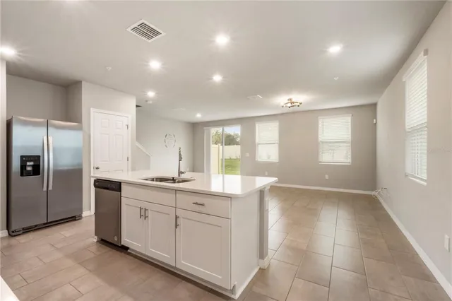 a large kitchen with kitchen island a sink stainless steel appliances and cabinets