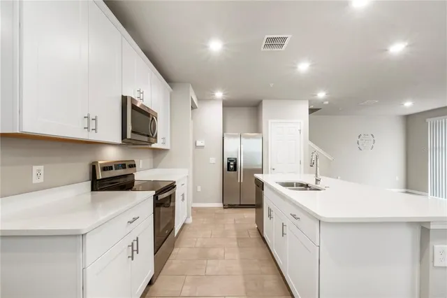 a large white kitchen with stainless steel appliances