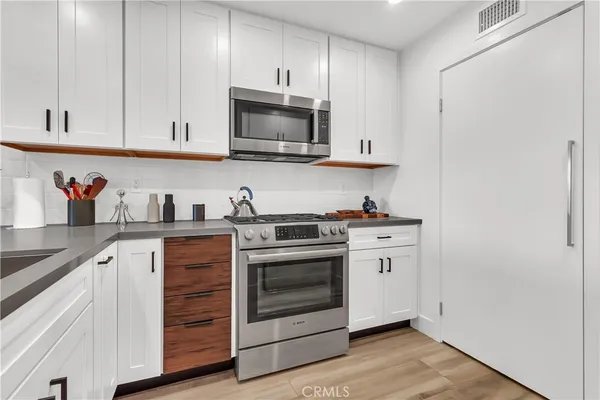 a kitchen with stainless steel appliances granite countertop a sink and a microwave