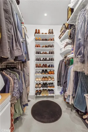 a view of walk in closet with clothes and shoes