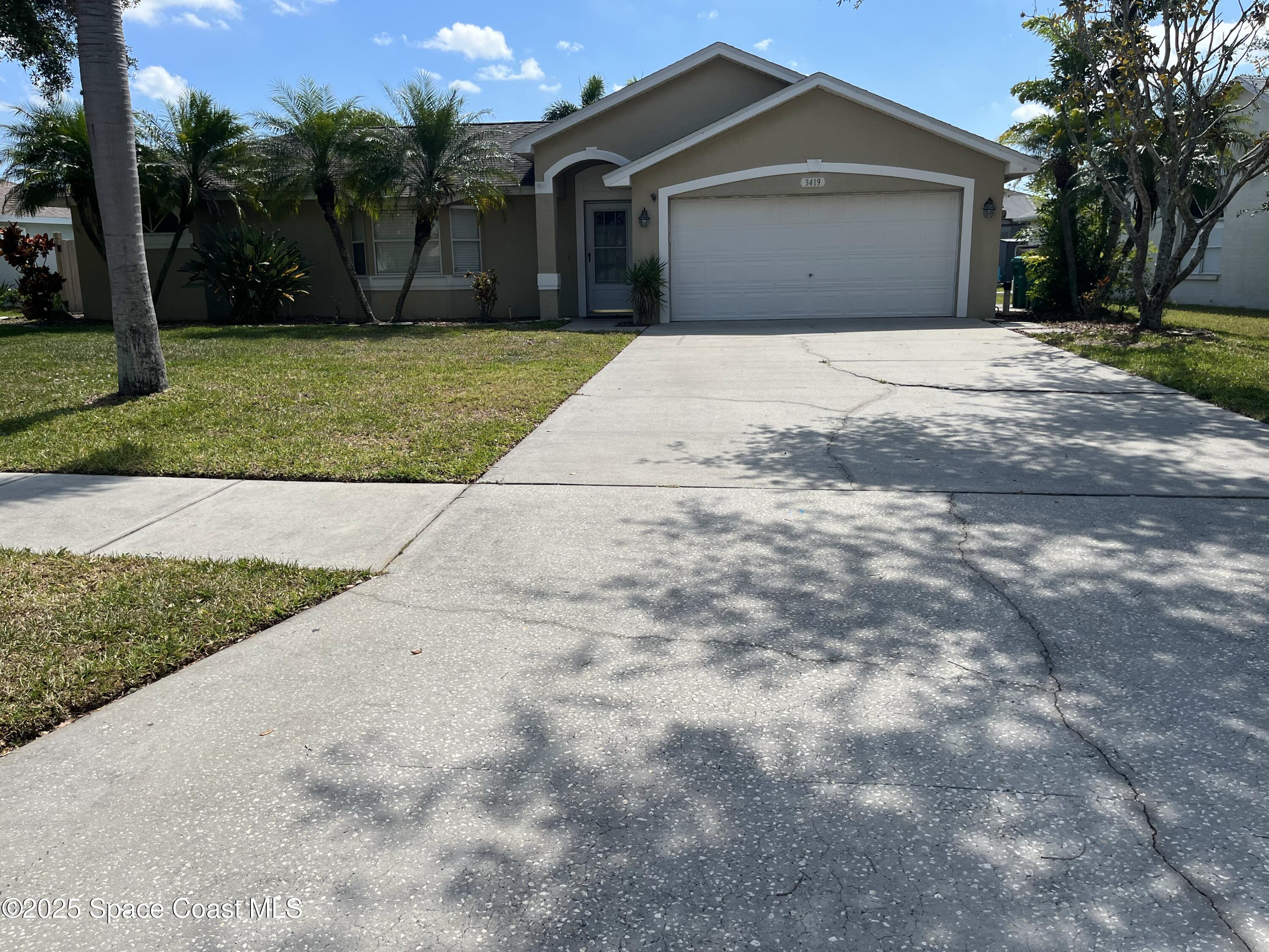 2209 McCormack Way Melbourne, FL 32935 - Photo 1 of 22 a front view of a house with a yard and garage