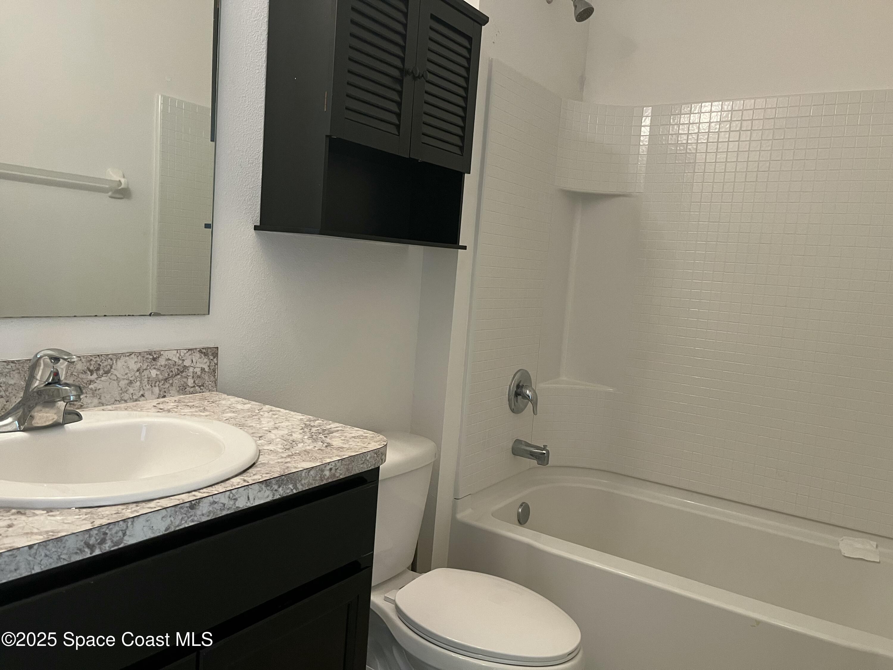 2209 McCormack Way Melbourne, FL 32935 - Photo 11 of 22 a bathroom with a granite countertop sink toilet and bathtub