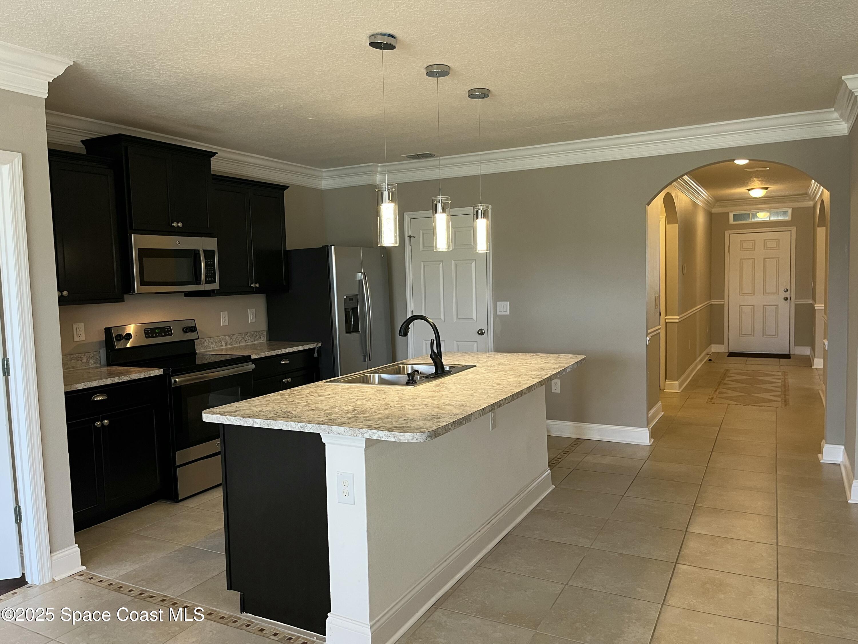 2209 McCormack Way Melbourne, FL 32935 - Photo 5 of 22 a kitchen with stainless steel appliances granite countertop a sink and a refrigerator