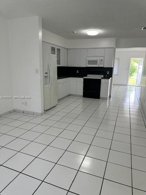 312 Southwest 76th Court, Unit 1 Miami, FL 33144 - Photo 7 of 18 a large white kitchen with a stove a refrigerator and a sink