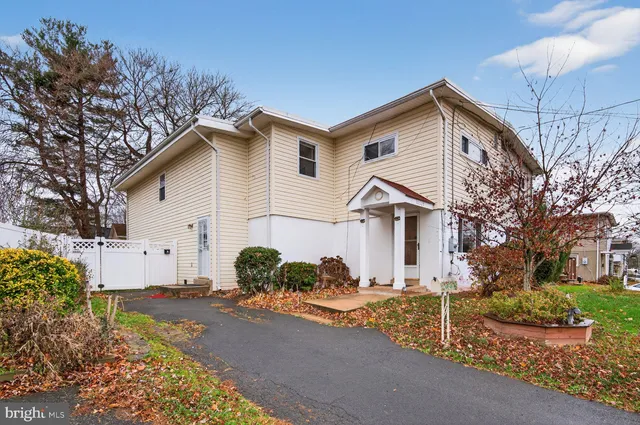 a view of a house with a yard and large tree