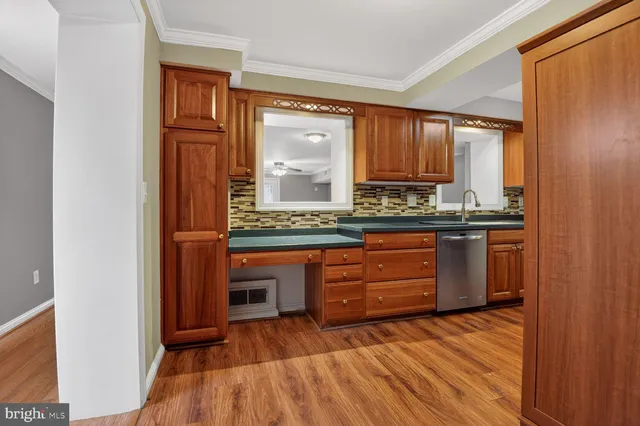 a room with granite countertop a sink and a wooden cabinets