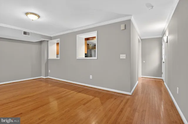 a view of an empty room with wooden floor