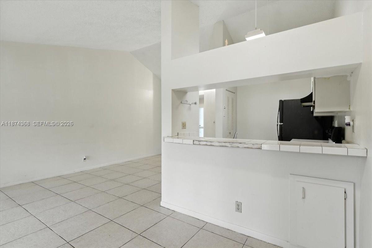9167 Southwest 138th Place, Unit 9167 Miami, FL 33186 - Photo 5 of 16 a view of kitchen with refrigerator and microwave