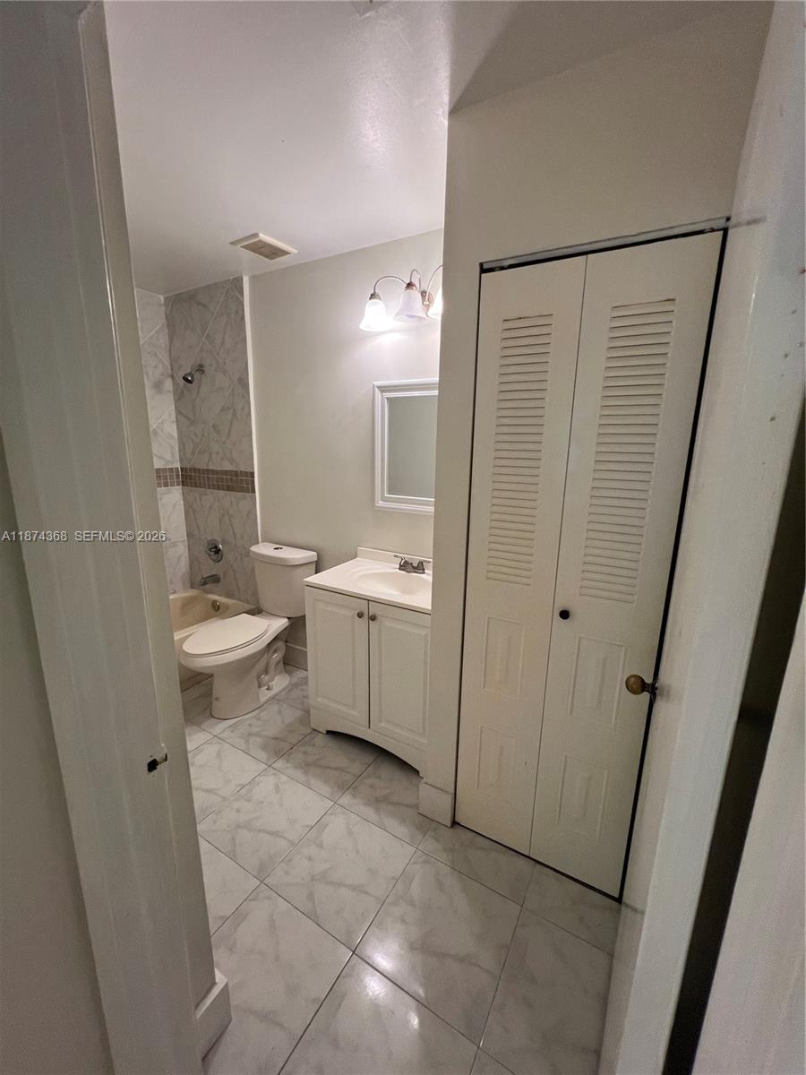 9167 Southwest 138th Place, Unit 9167 Miami, FL 33186 - Photo 6 of 16 a bathroom with a sink a toilet and a mirror