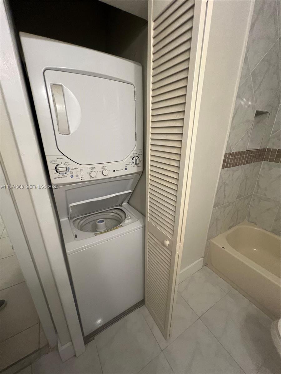 9167 Southwest 138th Place, Unit 9167 Miami, FL 33186 - Photo 8 of 16 a bathroom with a washer and dryer