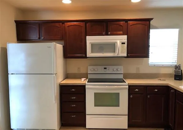 a kitchen with a refrigerator sink and stove top oven