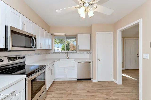a kitchen with stainless steel appliances a sink cabinets and wooden floor