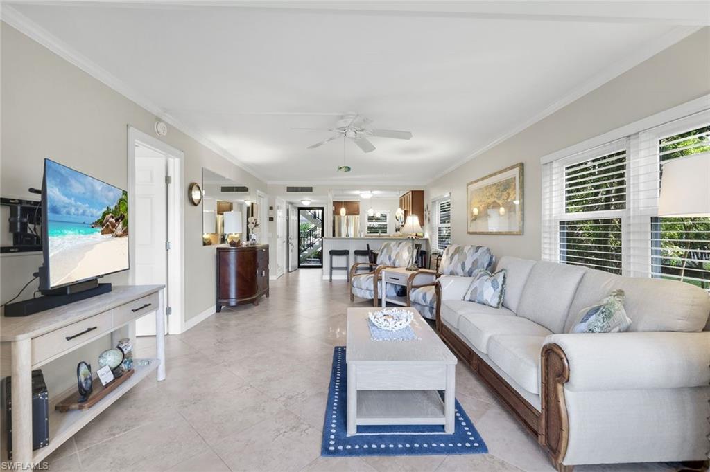 201 Quail Forest Boulevard, Unit 101 Naples, FL 34105 - Photo 32 of 32 a living room with furniture and a flat screen tv