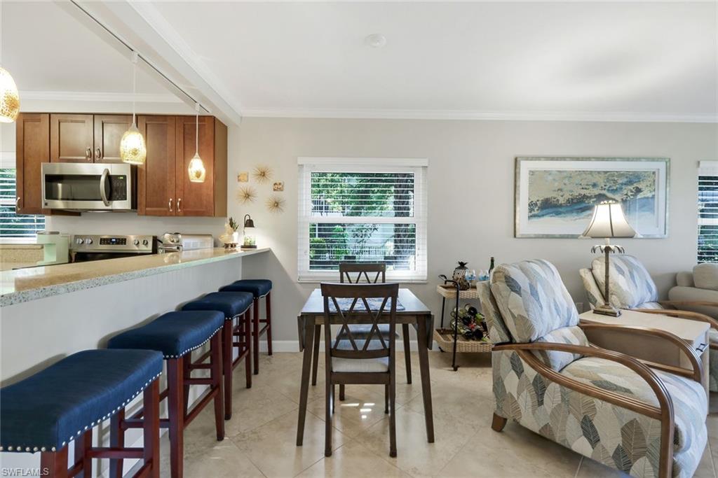 201 Quail Forest Boulevard, Unit 101 Naples, FL 34105 - Photo 13 of 32 a view of a dining room with furniture