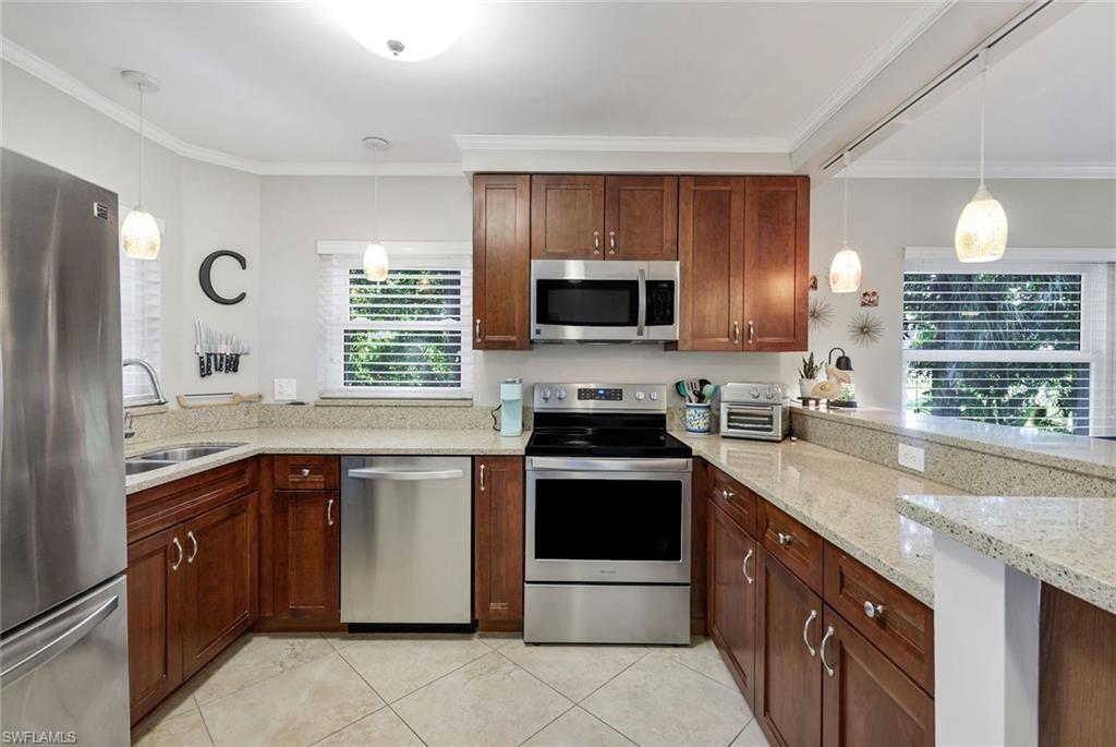 201 Quail Forest Boulevard, Unit 101 Naples, FL 34105 - Photo 16 of 32 a kitchen with a sink stove and microwave