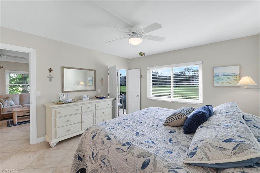 201 Quail Forest Boulevard, Unit 101 Naples, FL 34105 - Photo 17 of 32 a bedroom with a large bed and a flat screen tv