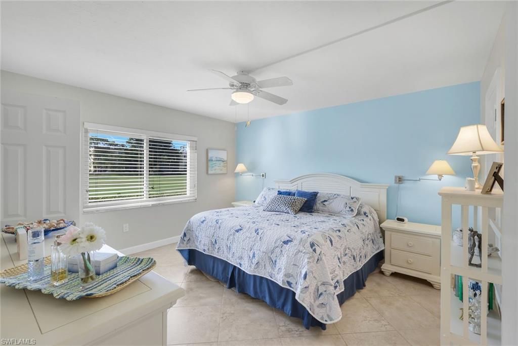 201 Quail Forest Boulevard, Unit 101 Naples, FL 34105 - Photo 18 of 32 a bedroom with a bed and ceiling fan