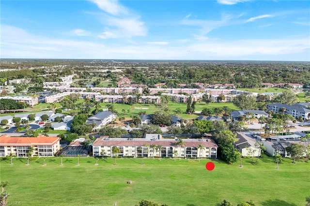an aerial view of a city with lots of residential buildings ocean and mountain view in back