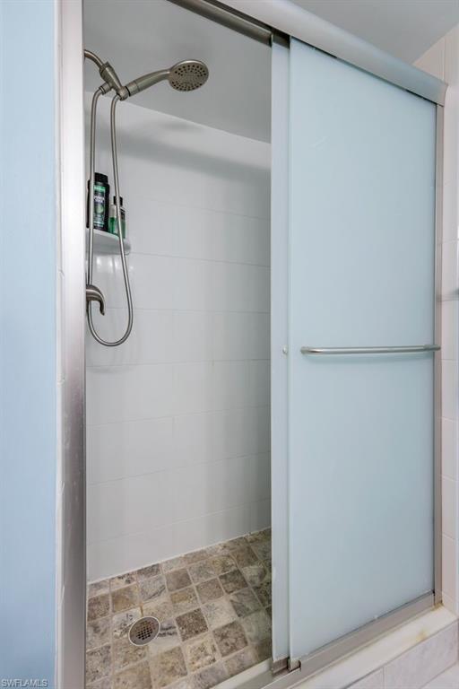 201 Quail Forest Boulevard, Unit 101 Naples, FL 34105 - Photo 22 of 32 a bathroom with a glass shower door