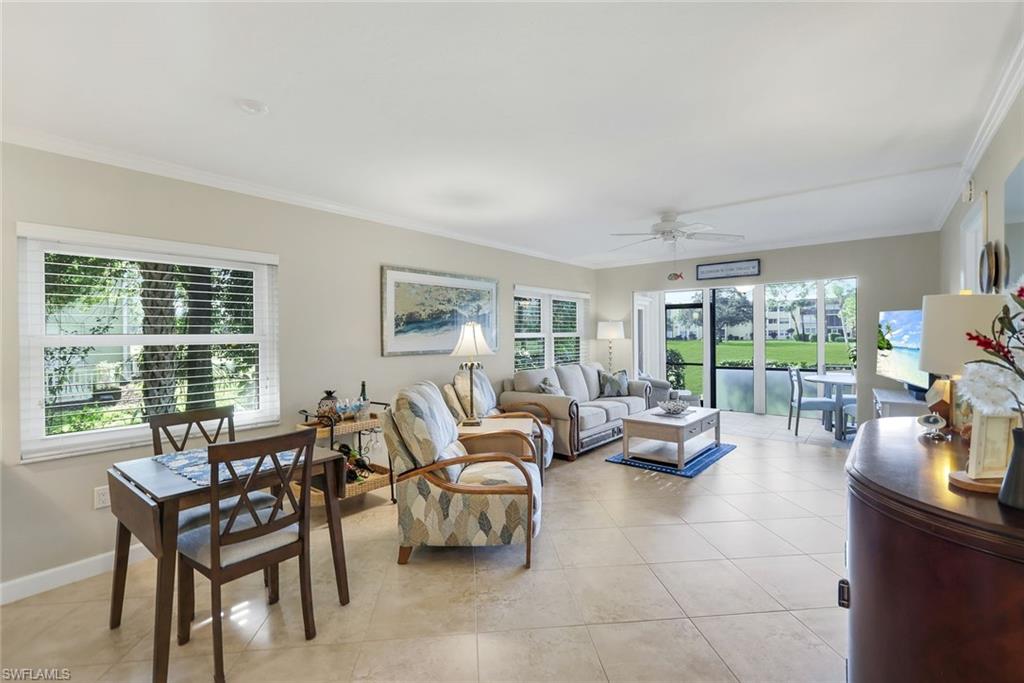 201 Quail Forest Boulevard, Unit 101 Naples, FL 34105 - Photo 31 of 32 a living room with furniture and a floor to ceiling window