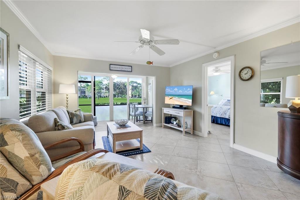 201 Quail Forest Boulevard, Unit 101 Naples, FL 34105 - Photo 7 of 32 a living room with furniture and a large window