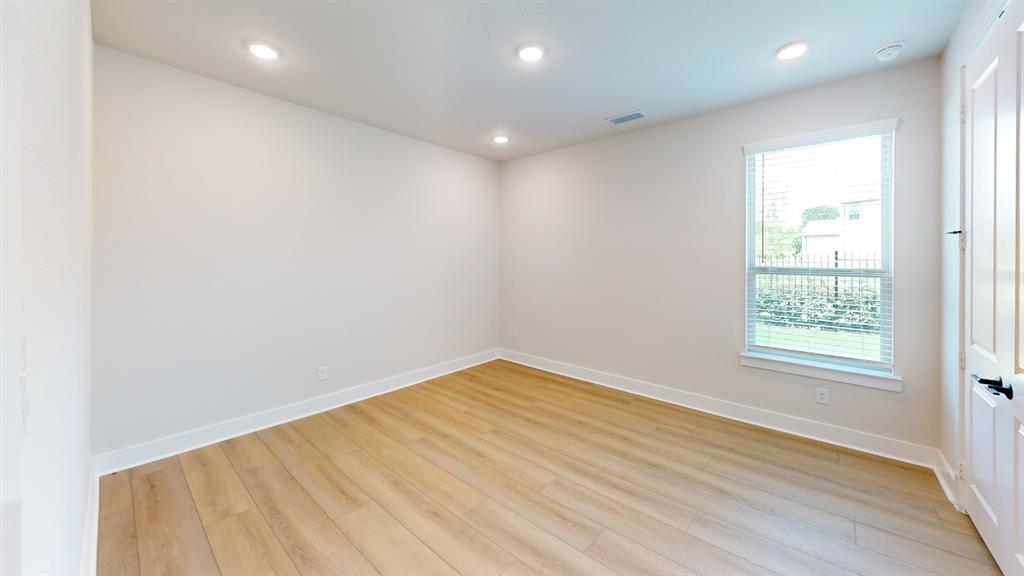 2708 Andesite Road McKinney, TX 75071 - Photo 33 of 35 Bright interior space featuring light wood-finish flooring, recessed lighting, a single window with blinds, and a white panel door with dark hardware