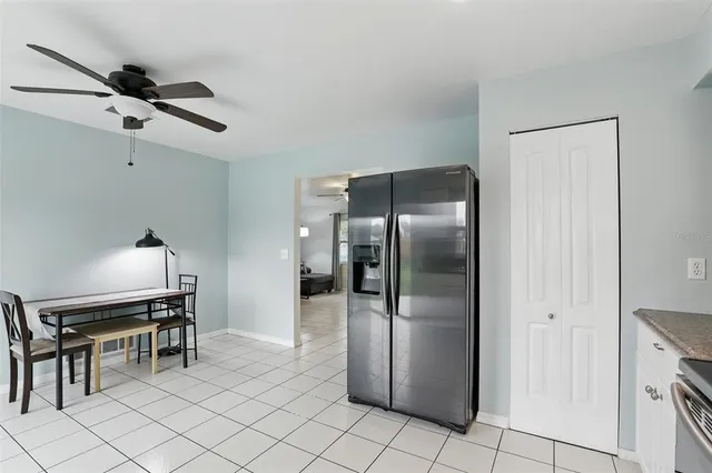 a kitchen with stainless steel appliances kitchen island granite countertop a refrigerator and a stove top oven