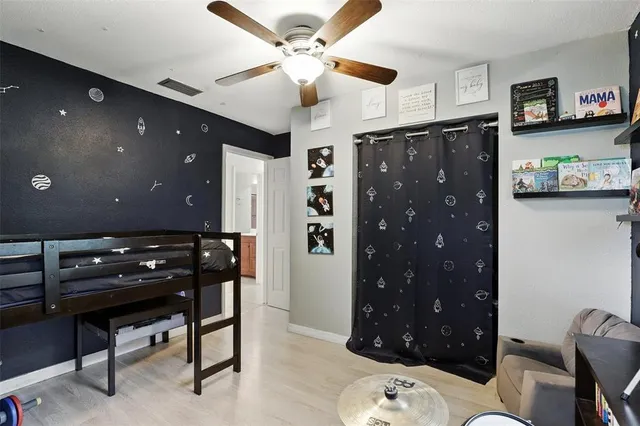 a room with a black furniture a chandelier a rug and a window