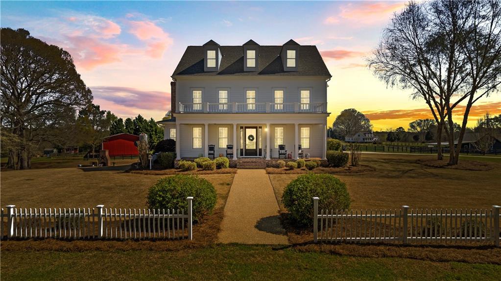 a view of a house with floor to ceiling windows and a table and chairs