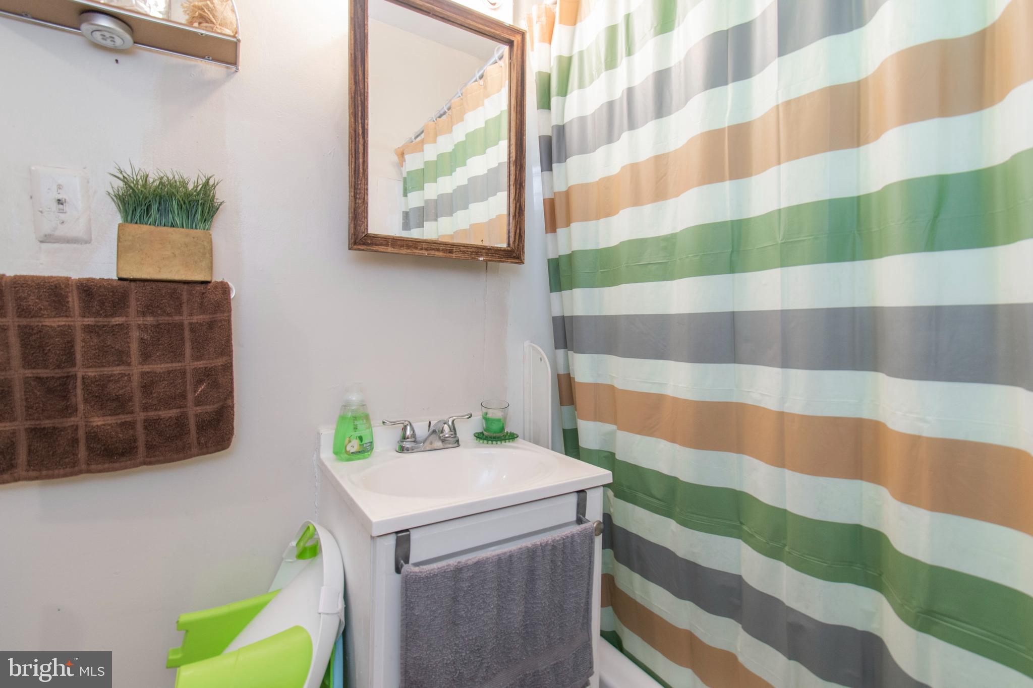 3317 Malta Street Philadelphia, PA 19134 - Photo 17 of 17 a bathroom with a sink and a shower curtain