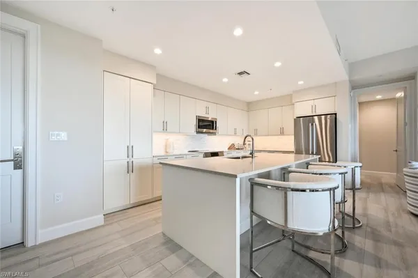 a kitchen with a sink a counter top space and stainless steel appliances