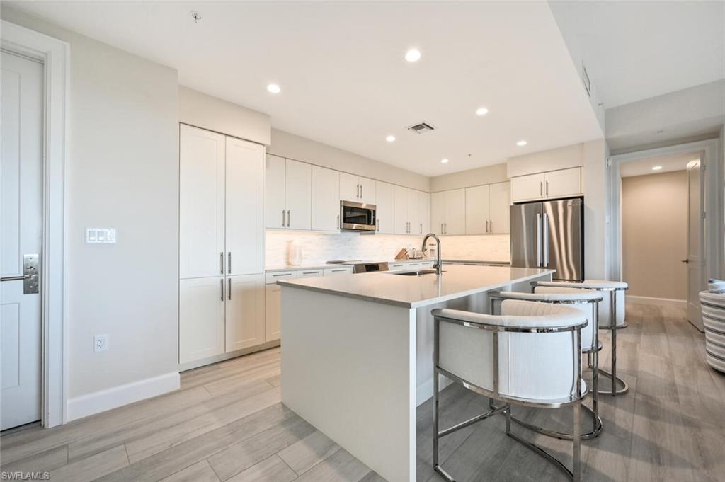 1111 Central Avenue, Unit 511 Naples, FL 34102 - Photo 12 of 50 a kitchen with a sink a counter top space and stainless steel appliances