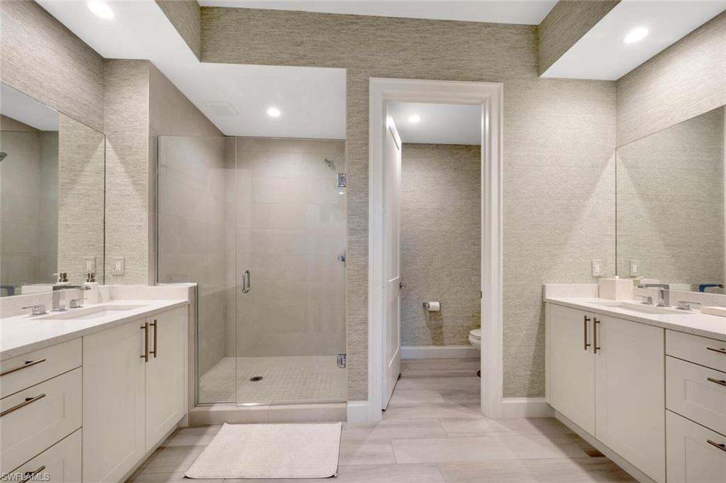 1111 Central Avenue, Unit 511 Naples, FL 34102 - Photo 23 of 50 a bathroom with a double vanity sink a toilet and shower