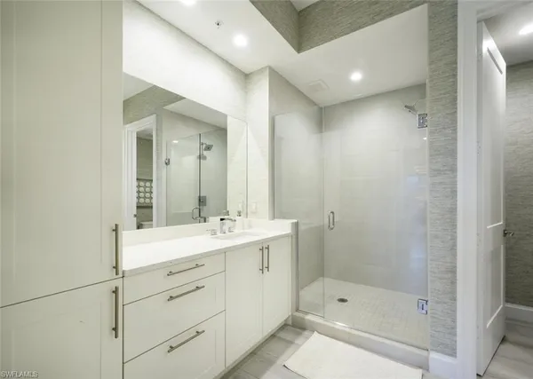 a bathroom with a shower sink and mirror