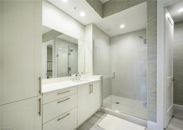 a bathroom with a shower sink and mirror