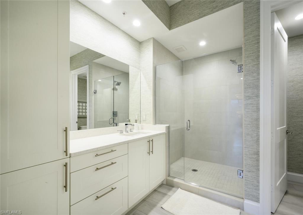 1111 Central Avenue, Unit 511 Naples, FL 34102 - Photo 24 of 50 a bathroom with a shower sink and mirror