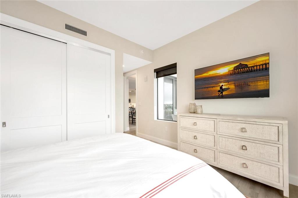 1111 Central Avenue, Unit 511 Naples, FL 34102 - Photo 27 of 50 a bedroom with a bed and a flat screen tv