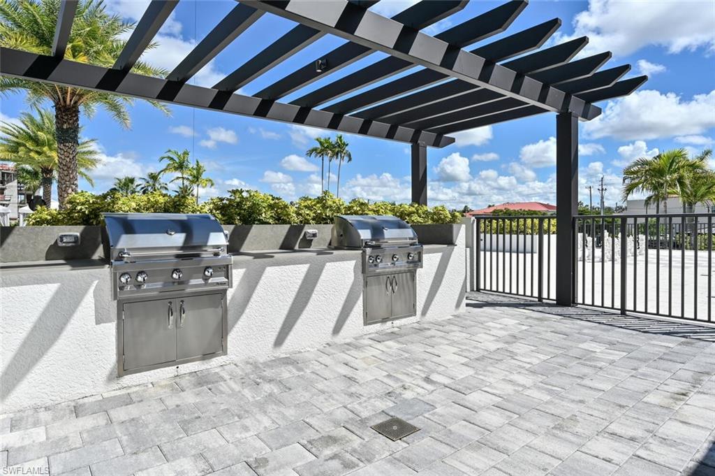 1111 Central Avenue, Unit 511 Naples, FL 34102 - Photo 44 of 50 a view of a chair and tables in the patio